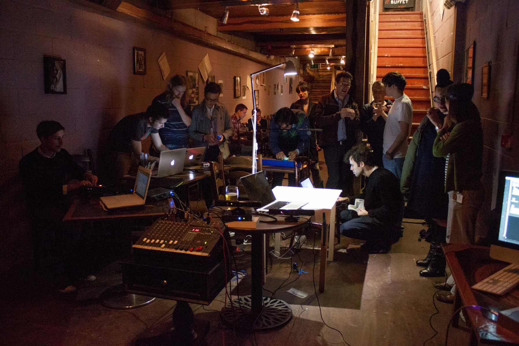 Artists experiment with electronic instruments and laptops during an early group session.